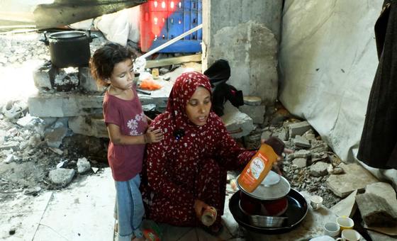 Khadija Manoun et sa fille dans une cuisine de fortune, à l'intérieur d'un bâtiment détruit.